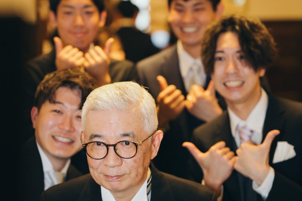 写真を撮る新郎友人と新郎父