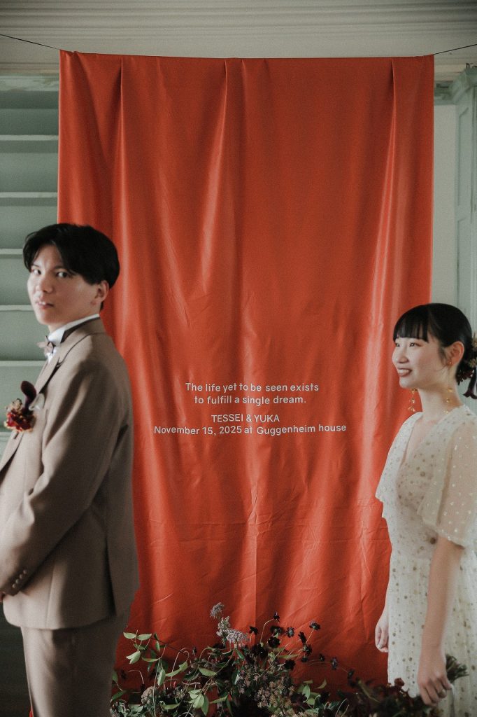 オレンジタペストリーの前で写真撮影