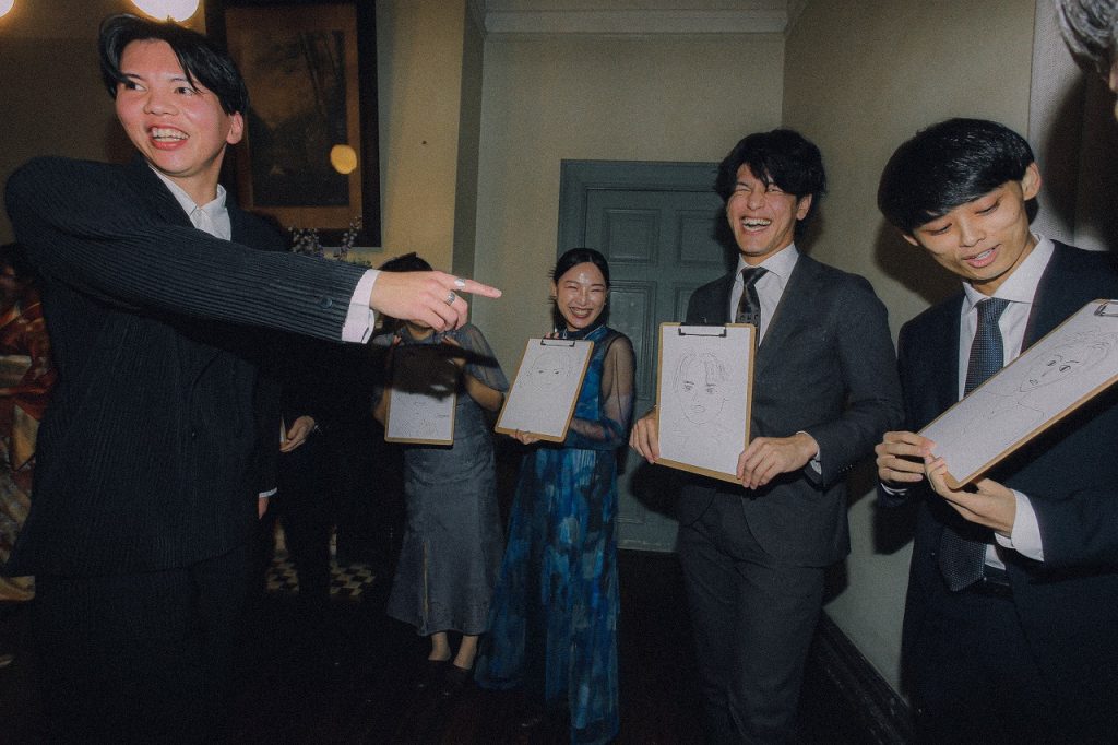 ゲストが描いた似顔絵を見る新郎